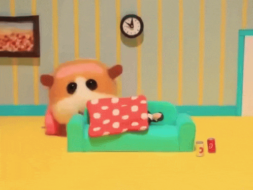 a stuffed animal is sleeping on a green couch in a living room .
