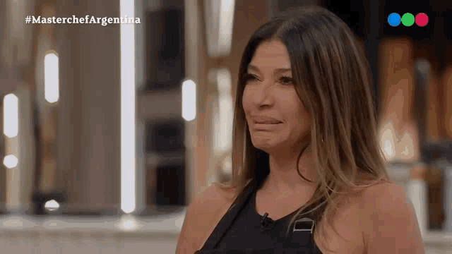 a woman in a black dress is crying on a television show