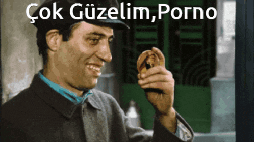 a man in a hat is smiling and holding something in his hand with the caption çok güzelim porno