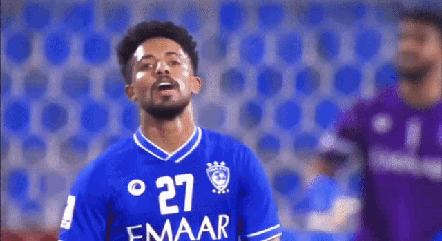 a soccer player wearing a blue jersey with the number 27