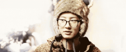 a man wearing glasses and a fur hat with ears .