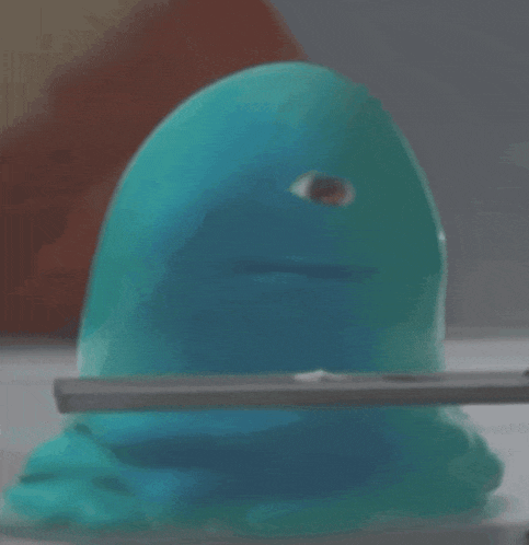 a blue toy with a big eye is being held by a person