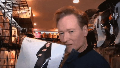 a man is holding a record which says emperor on it