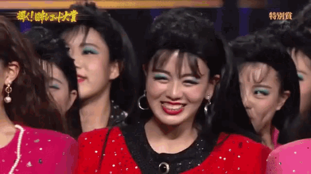 a woman in a red dress is smiling in front of other women