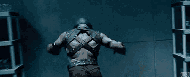 a man in a superhero costume is standing in front of a shelf with bottles on it