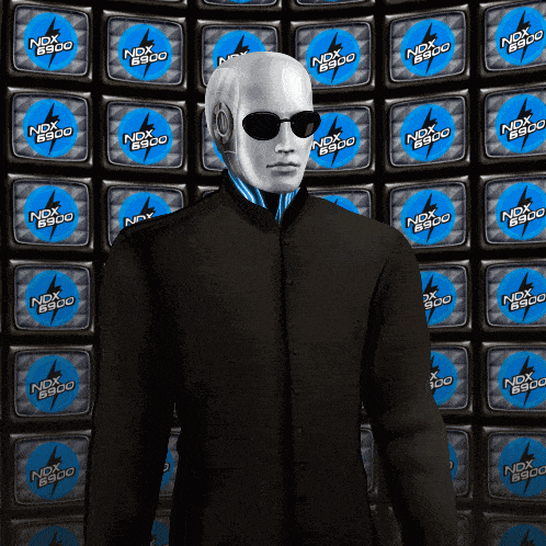 a man wearing sunglasses stands in front of a wall with ndx 8900 logos
