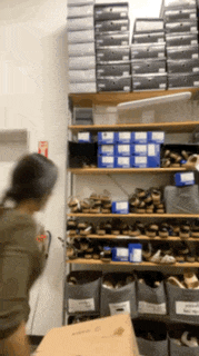 a person is standing in front of a shelf full of shoes