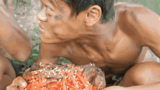 a shirtless man is eating a huge piece of meat