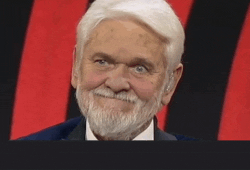 a man with white hair and a beard is smiling
