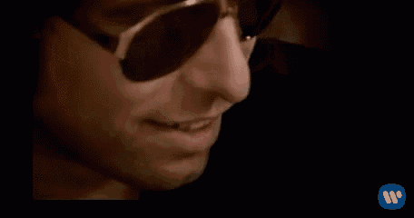 a close up of a man wearing sunglasses talking on a phone .