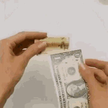 a person is folding a dollar bill into a book