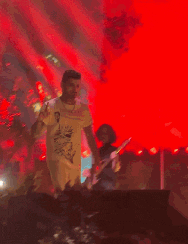 a man wearing a t-shirt that says ' supreme ' on it is singing into a microphone on a stage
