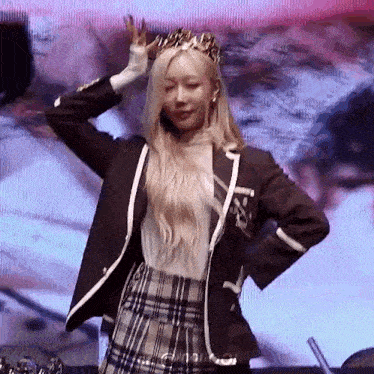 a woman wearing a crown is dancing on a stage .