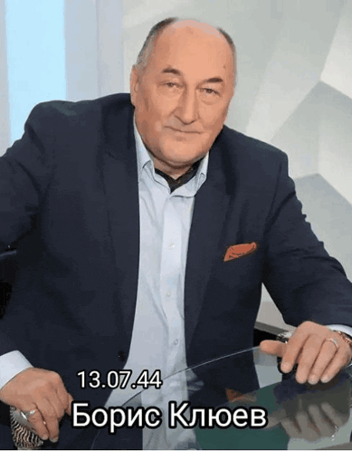 a man in a suit is sitting at a table with the date 13.07.44 on the bottom