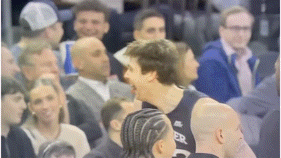 a blurry picture of a basketball player talking to another player in a crowd of people .