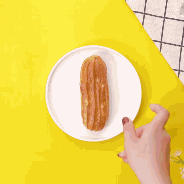 a person is pouring sauce on a donut on a white plate