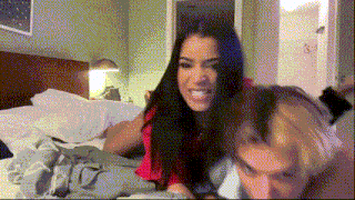 a man and a woman are laying on a bed and the woman is smiling .