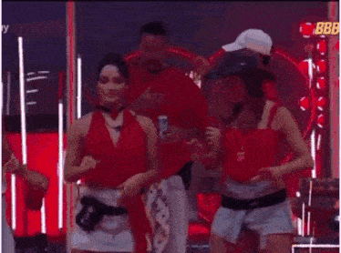 a group of people are dancing together in a room while a man holds a can of beer .