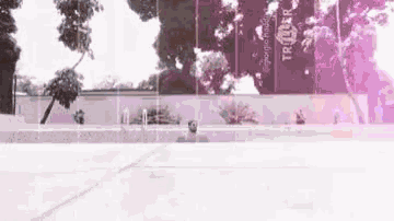 a man is doing a trick on a skateboard in front of a large sign .