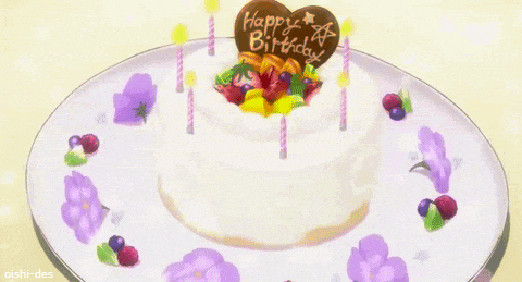 a birthday cake with candles and flowers on a white plate