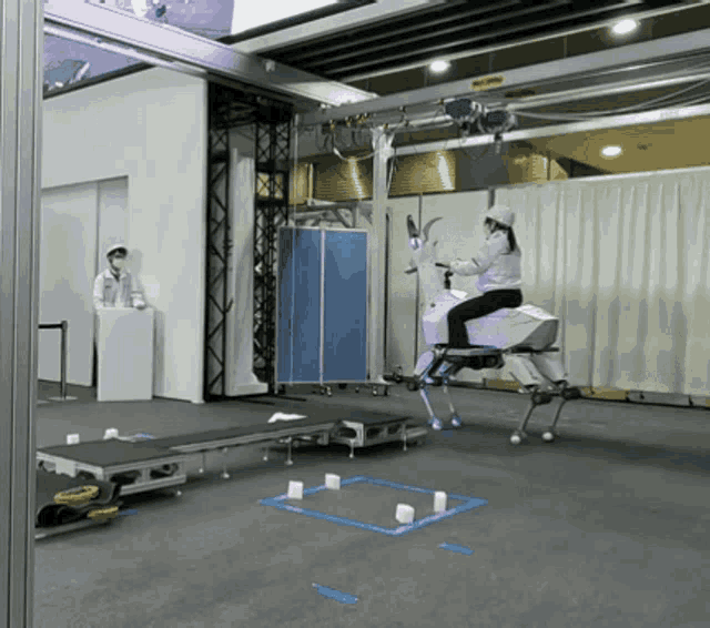 a woman is riding a robotic horse in a room with a sign that says " no entry "