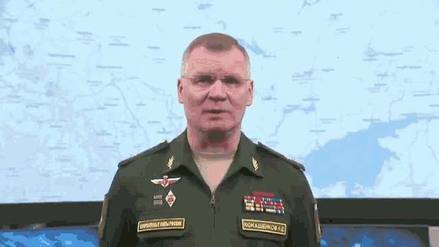 a man in a military uniform is standing in front of a map ..
