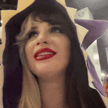 a woman wearing a purple and white hat with the number 57 behind her