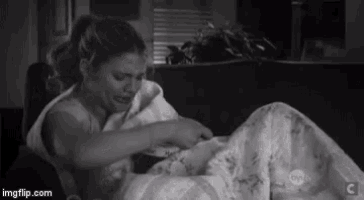 a woman is sitting on a couch holding a baby in her arms .