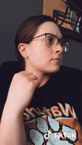 a woman wearing glasses and a black shirt that says sfw