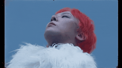 a person with red hair and a white fur coat