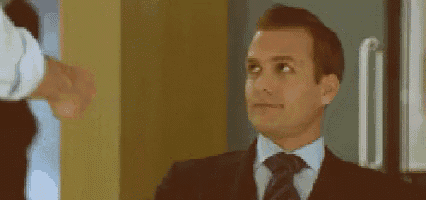 a man in a suit and tie is looking up at something while another man shakes his hand .