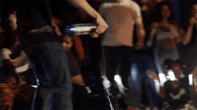 a man pouring water from a bottle that says ' n.w. ' on it