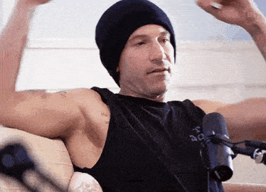 a man is sitting on a couch in front of a microphone .