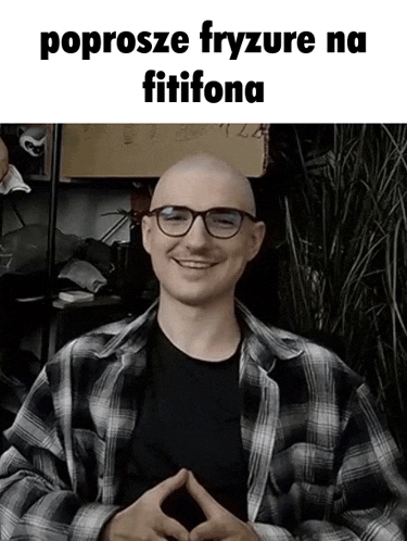 a man wearing glasses and a plaid shirt is smiling in a meme