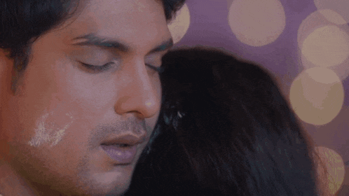 a man and a woman are kissing with their eyes closed