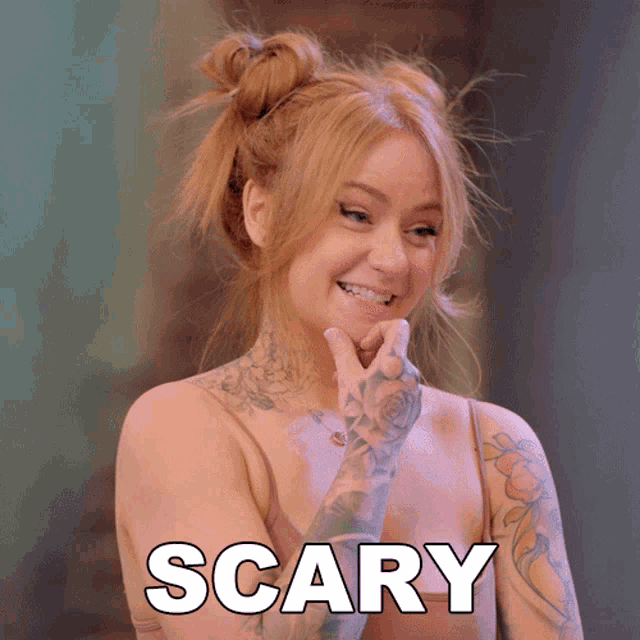 a woman with tattoos is smiling with the word scary above her head