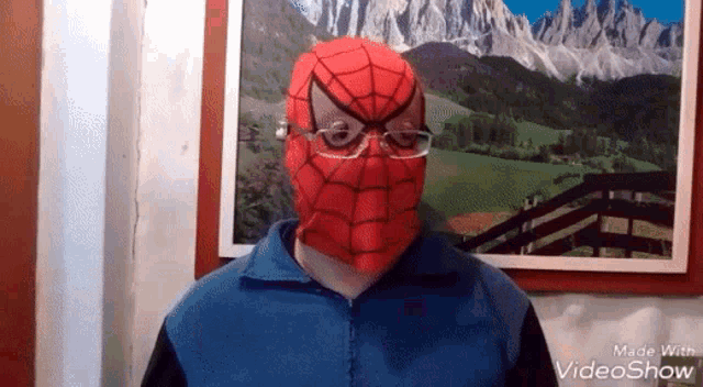 a man wearing a spiderman mask and glasses .