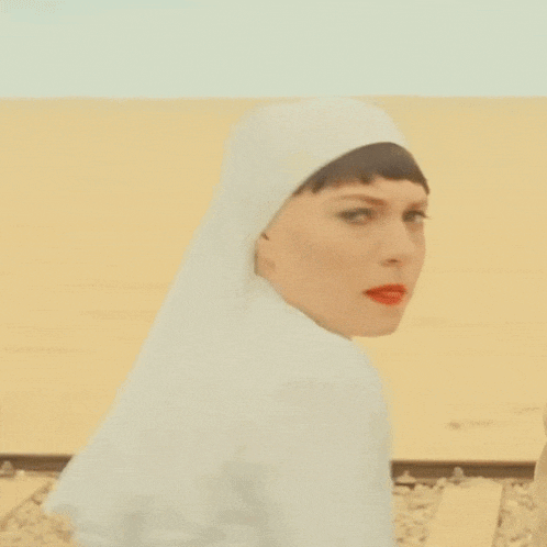 a woman in a nun costume is holding a knife in her hand .