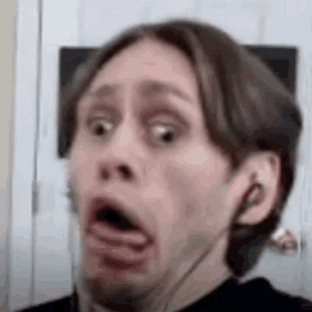 a man is wearing headphones and making a funny face .