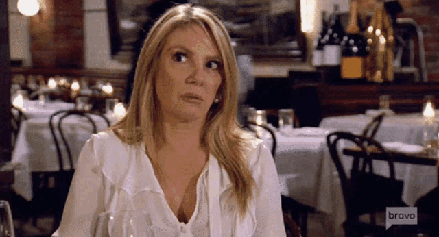 a woman is sitting at a table in a restaurant with bravo written on the bottom