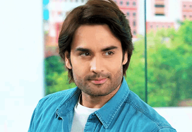 a man with long hair and a beard wearing a blue shirt