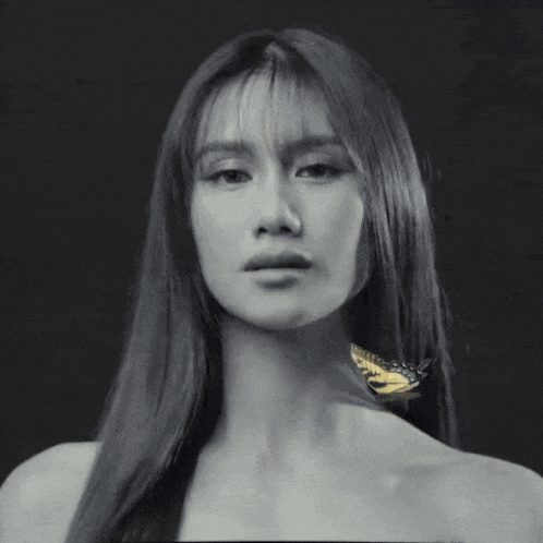 a woman with long hair has a butterfly on her neck .