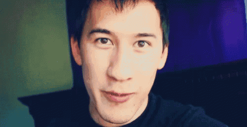 a close up of a man 's face with a purple background and a black shirt .