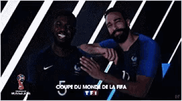 two soccer players are posing for a picture with the words coupe du monde de la fifa on the bottom