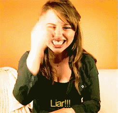 a woman sitting on a couch with the words liar written on her shirt