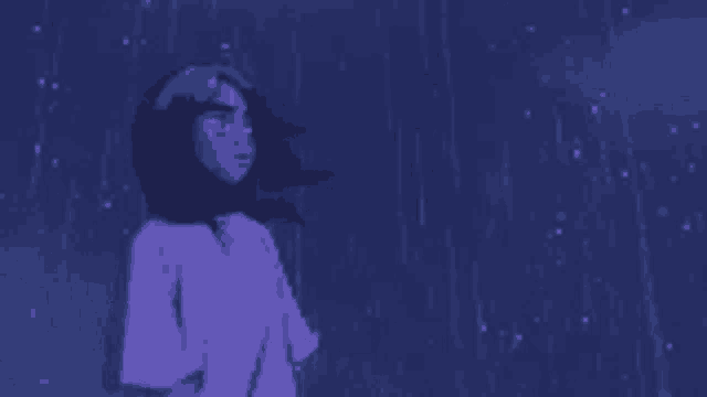 a girl in a purple shirt is standing in the rain at night .