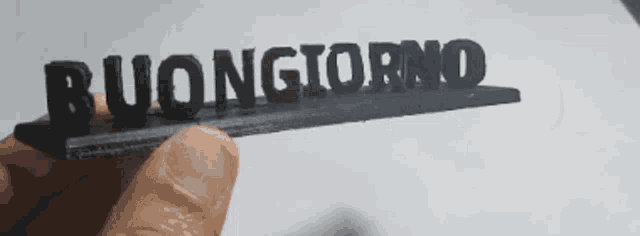 a person is holding a piece of paper with the word buongiorno on it