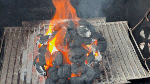a bunch of coals are burning in a grill