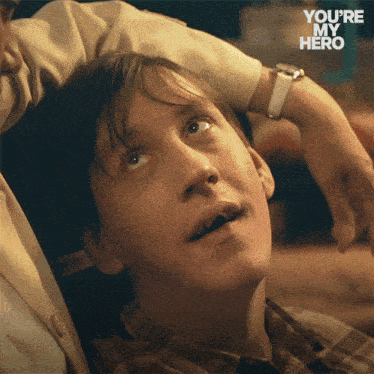 a close up of a man 's face with the words " you 're my hero " on the bottom right