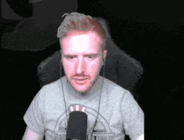 a man with a beard wearing a grey shirt that says ' army ' on it